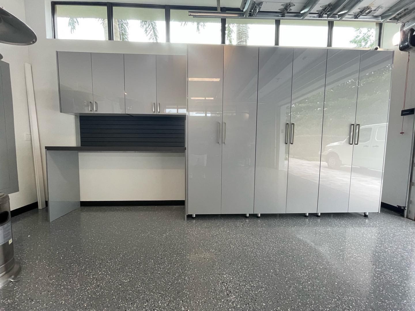 A garage with a lot of cabinets and a desk.