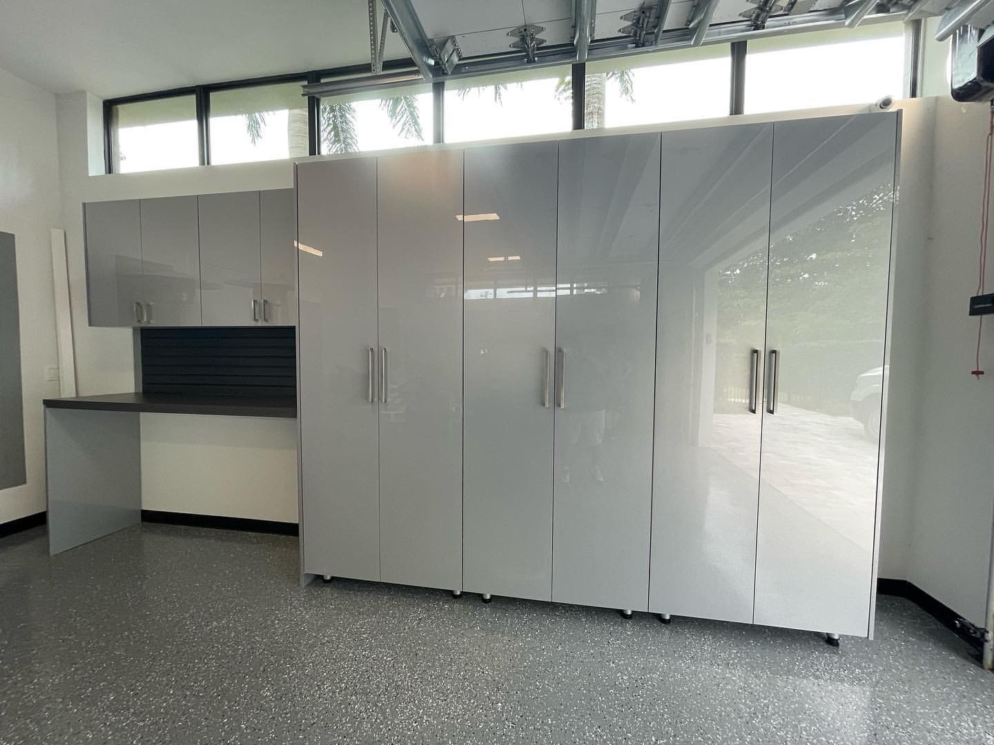 A garage with a lot of cabinets and a desk.