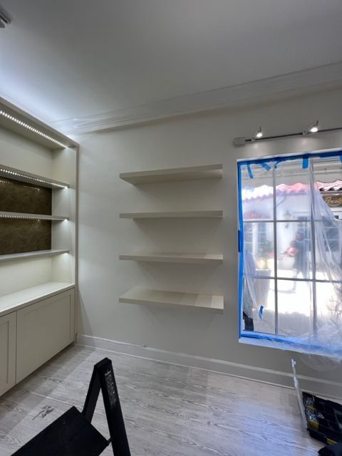 A room with shelves and a window with blue tape on it