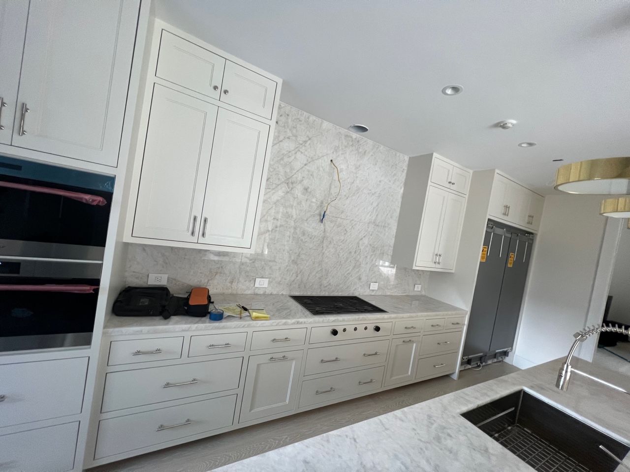 A kitchen with white cabinets and a stove top oven