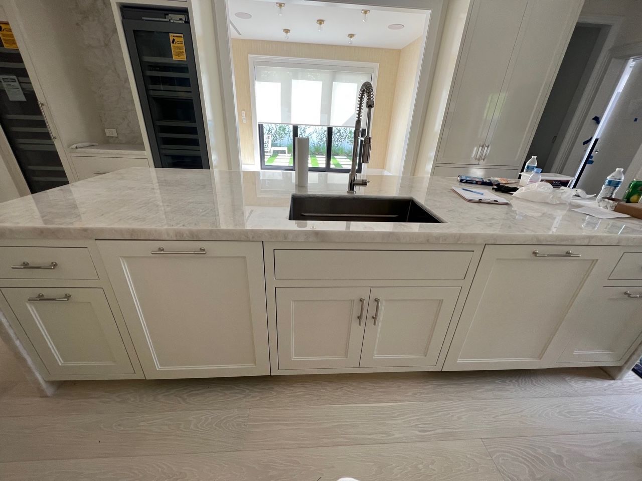 A kitchen with white cabinets and a sink.