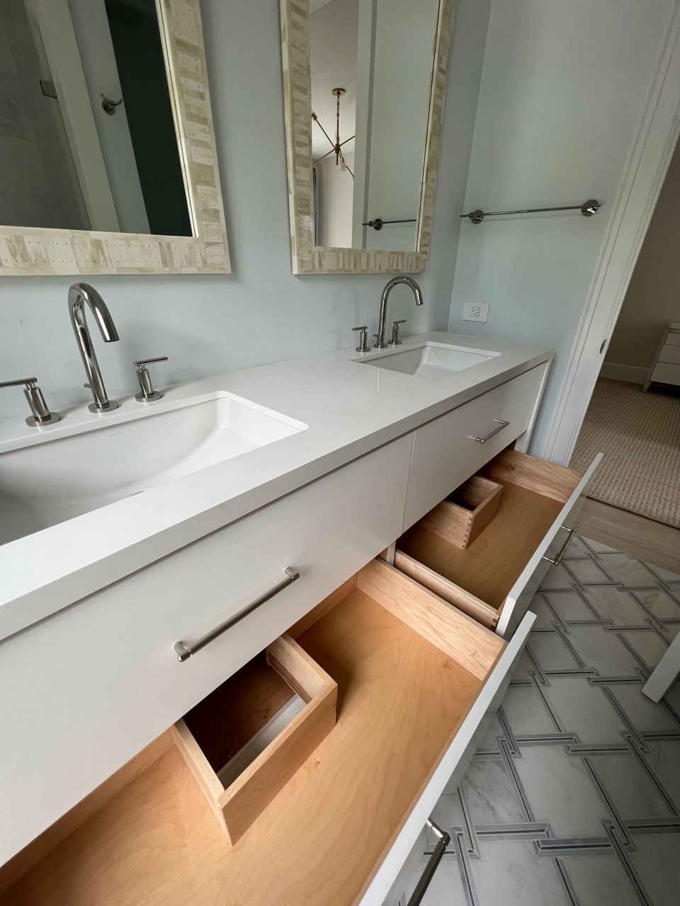 A bathroom with two sinks and two mirrors with drawers open