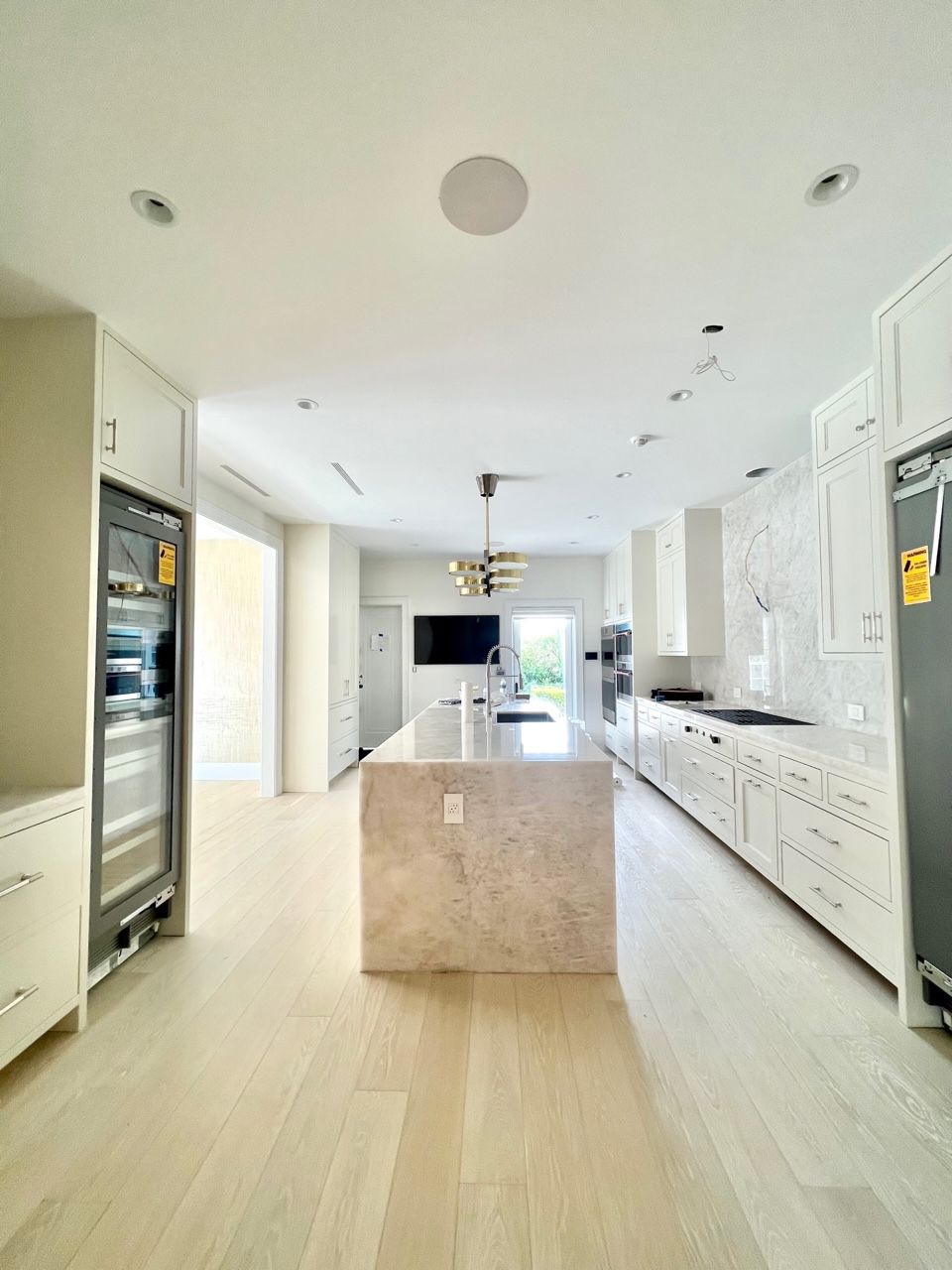 A kitchen with white cabinets and a large island in the middle