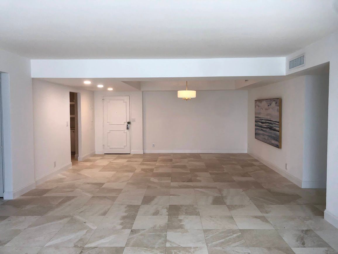 A large empty room with a tiled floor and white walls