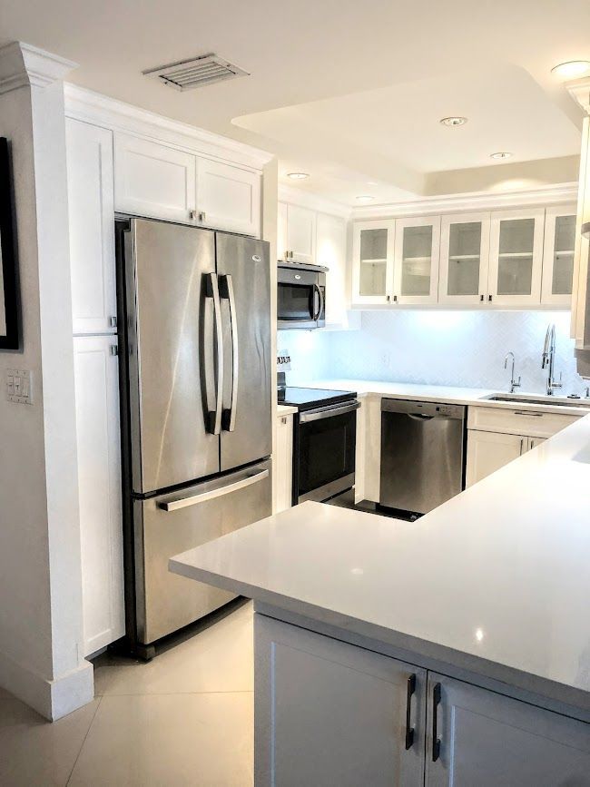 A kitchen with stainless steel appliances and white cabinets