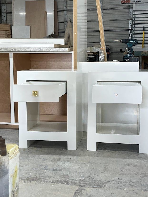 Two white nightstands are sitting next to each other in a room.