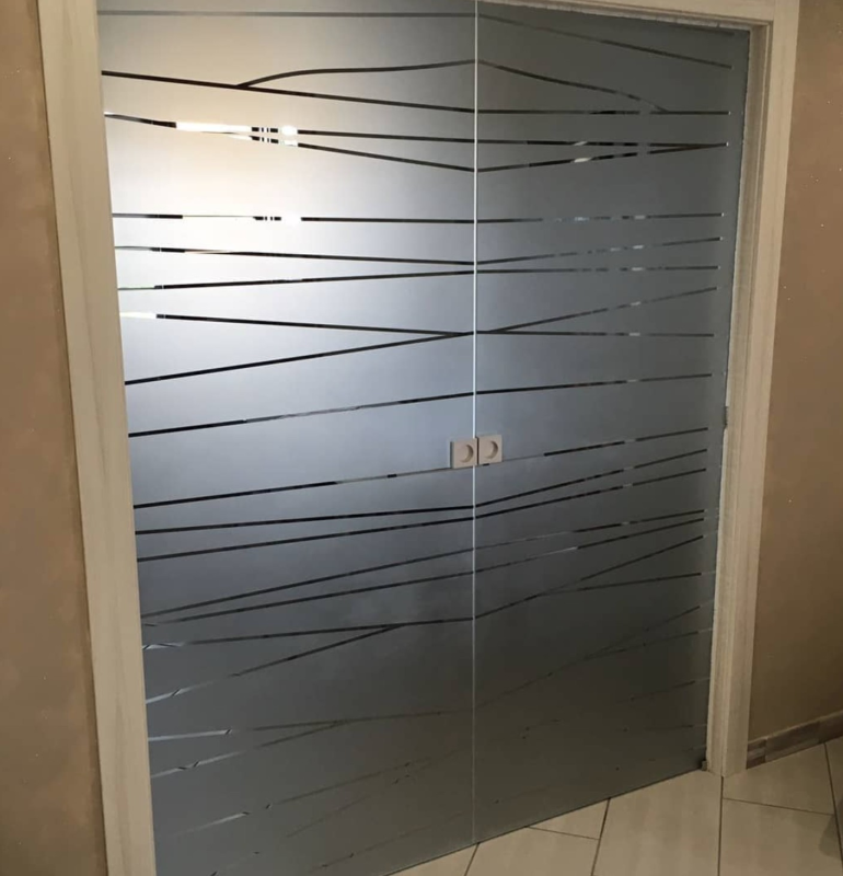 Porte scorrevoli in vetro smerigliato con linee nere orizzontali e astratte.