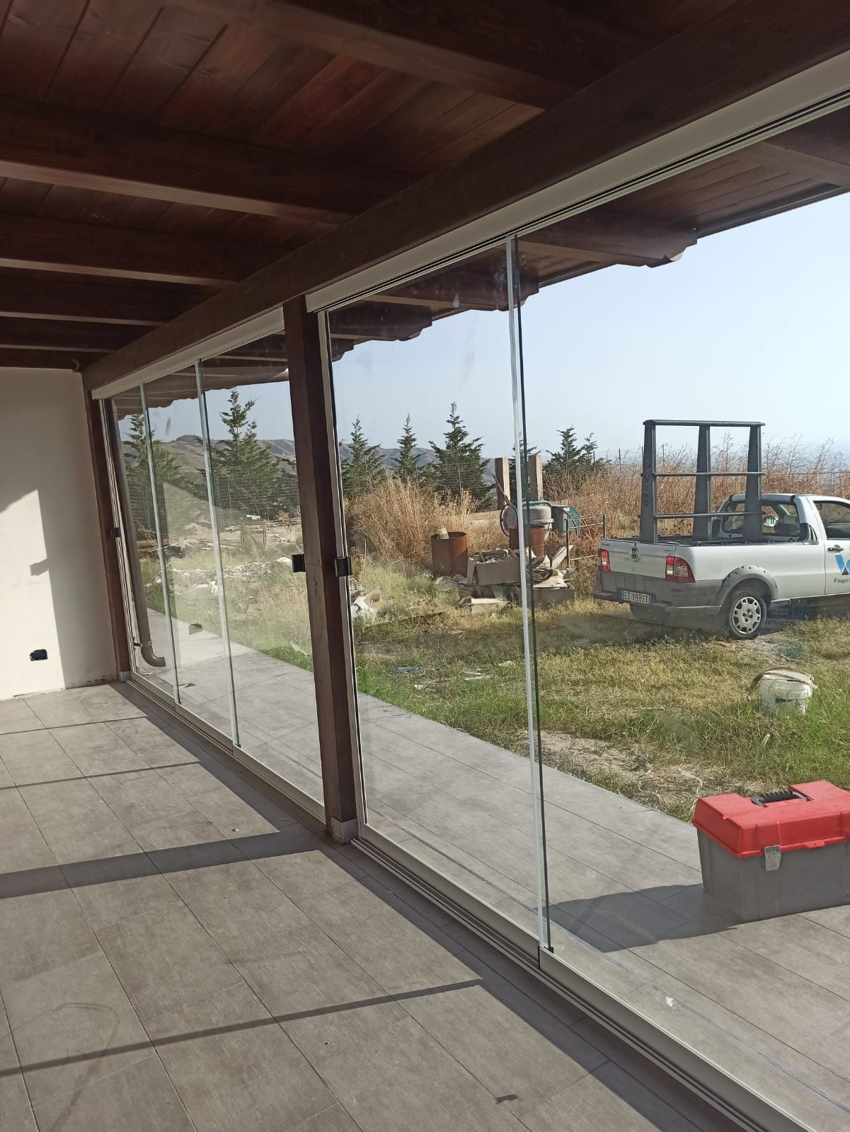 Scena di laboratorio con telai di finestre su un banco da lavoro; utensili e attrezzature visibili.