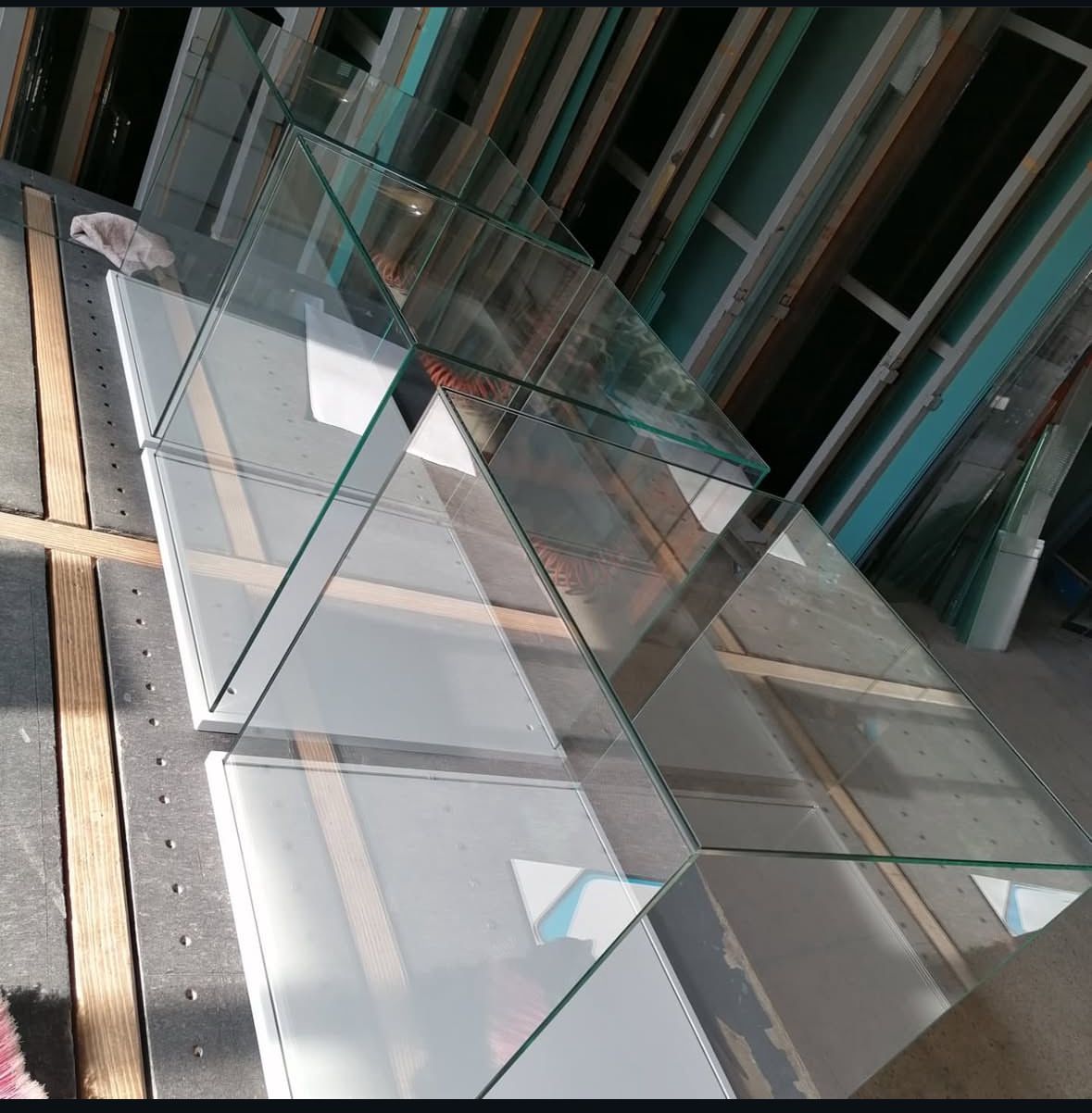 Pannelli di vetro su superfici bianche, che formano una struttura geometrica; ambientazione da laboratorio.