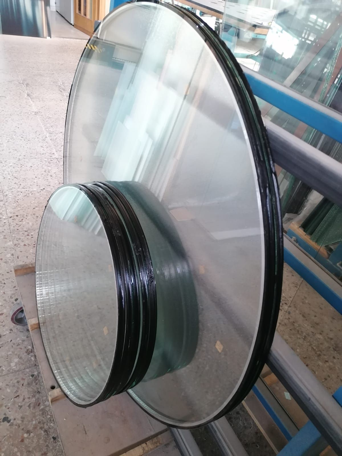 Pila di lastre di vetro rotonde con bordi neri.