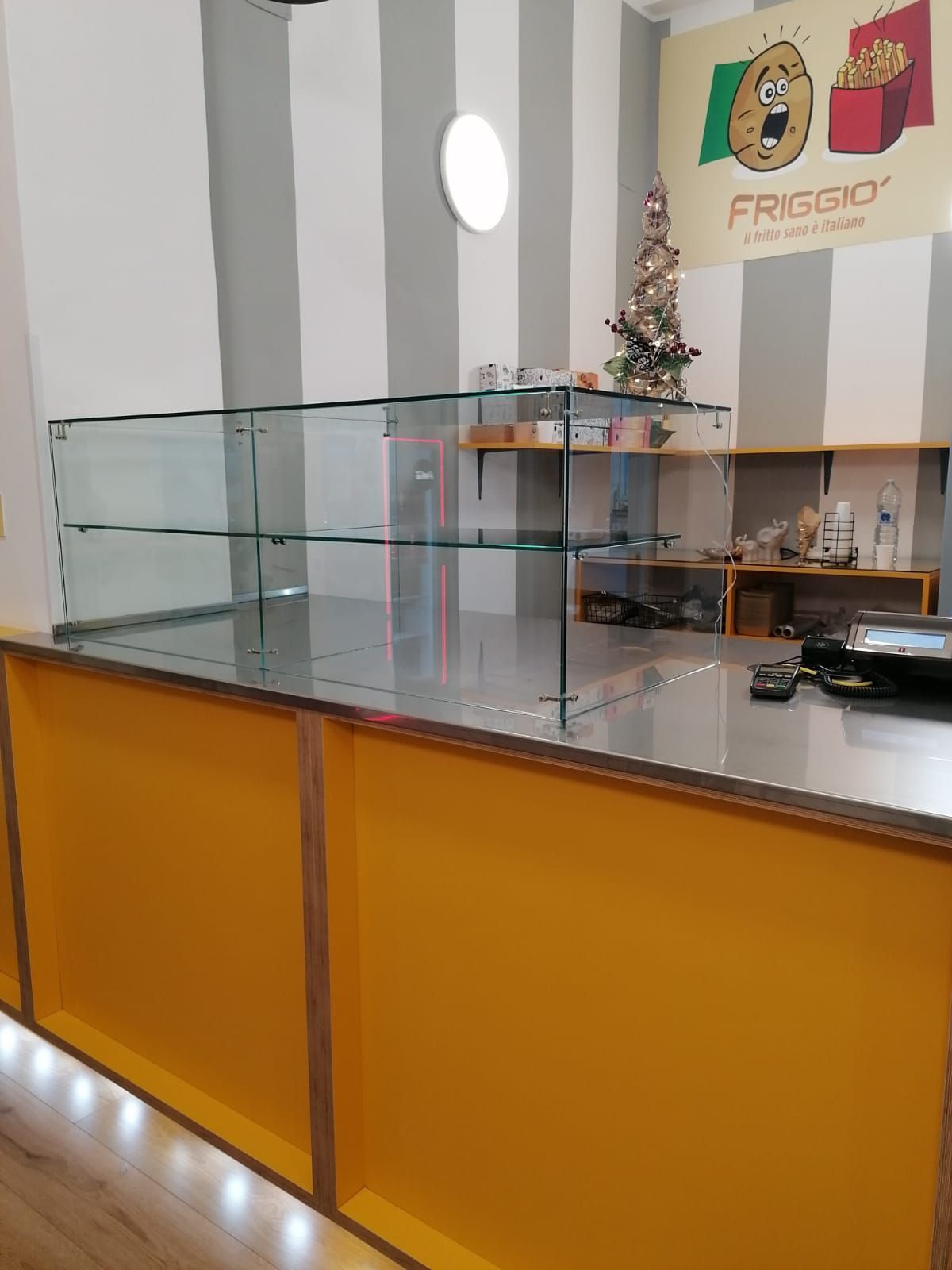 Una vetrina di pasticceria in una panetteria, piena di vari prodotti da forno, vicino a una grande finestra.