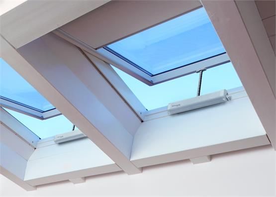 Two open skylights with blue sky visible, set in a white wooden frame.