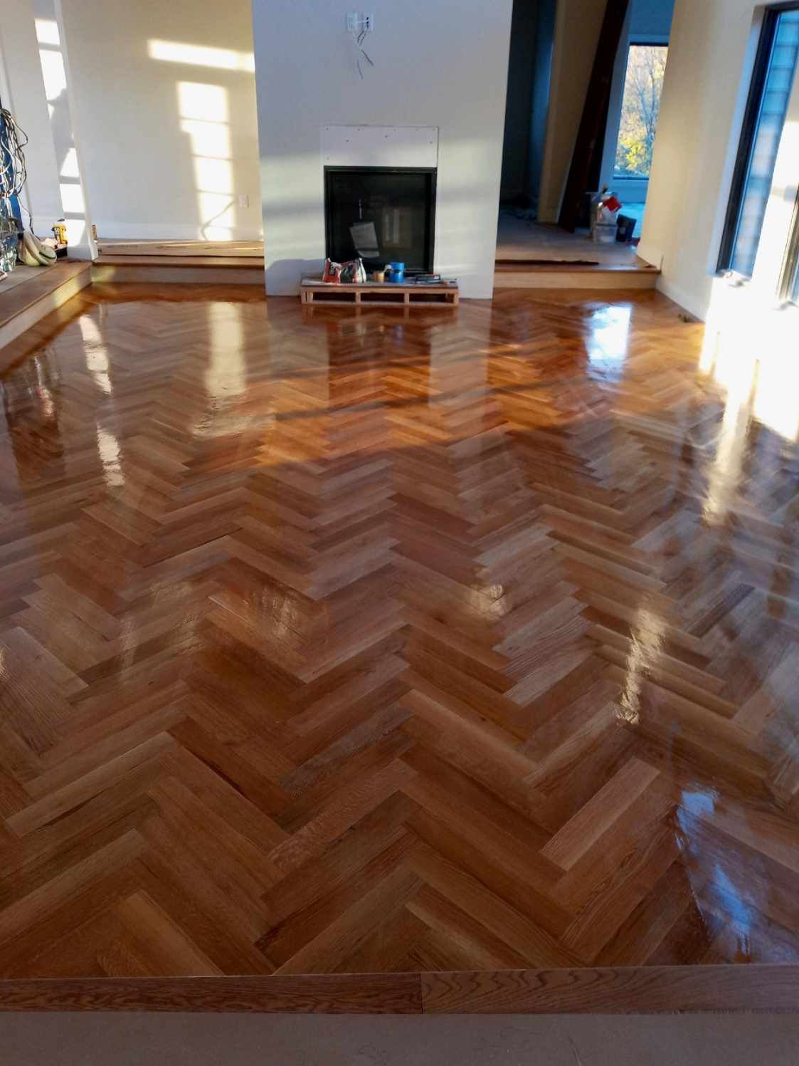 A living room with a wooden floor and a fireplace.