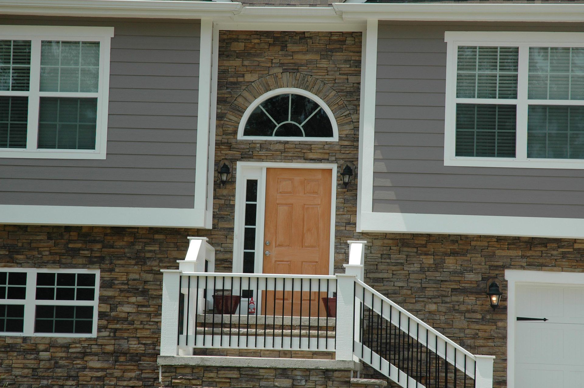 The front of a house with a balcony and stairs