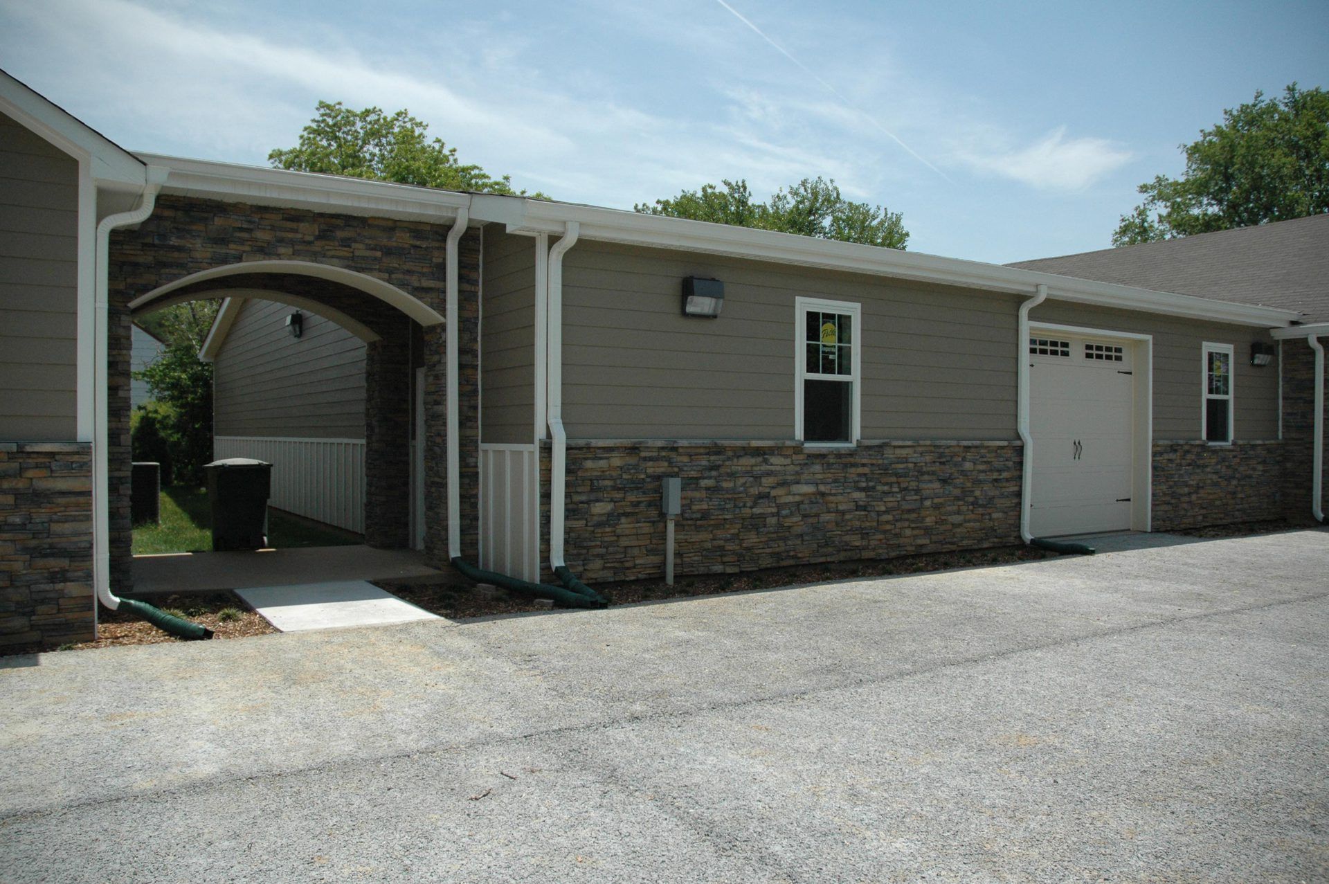 A house with a garage and a stone wall