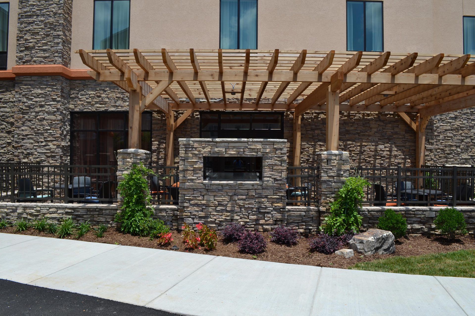 A large stone building with a wooden pergola over it
