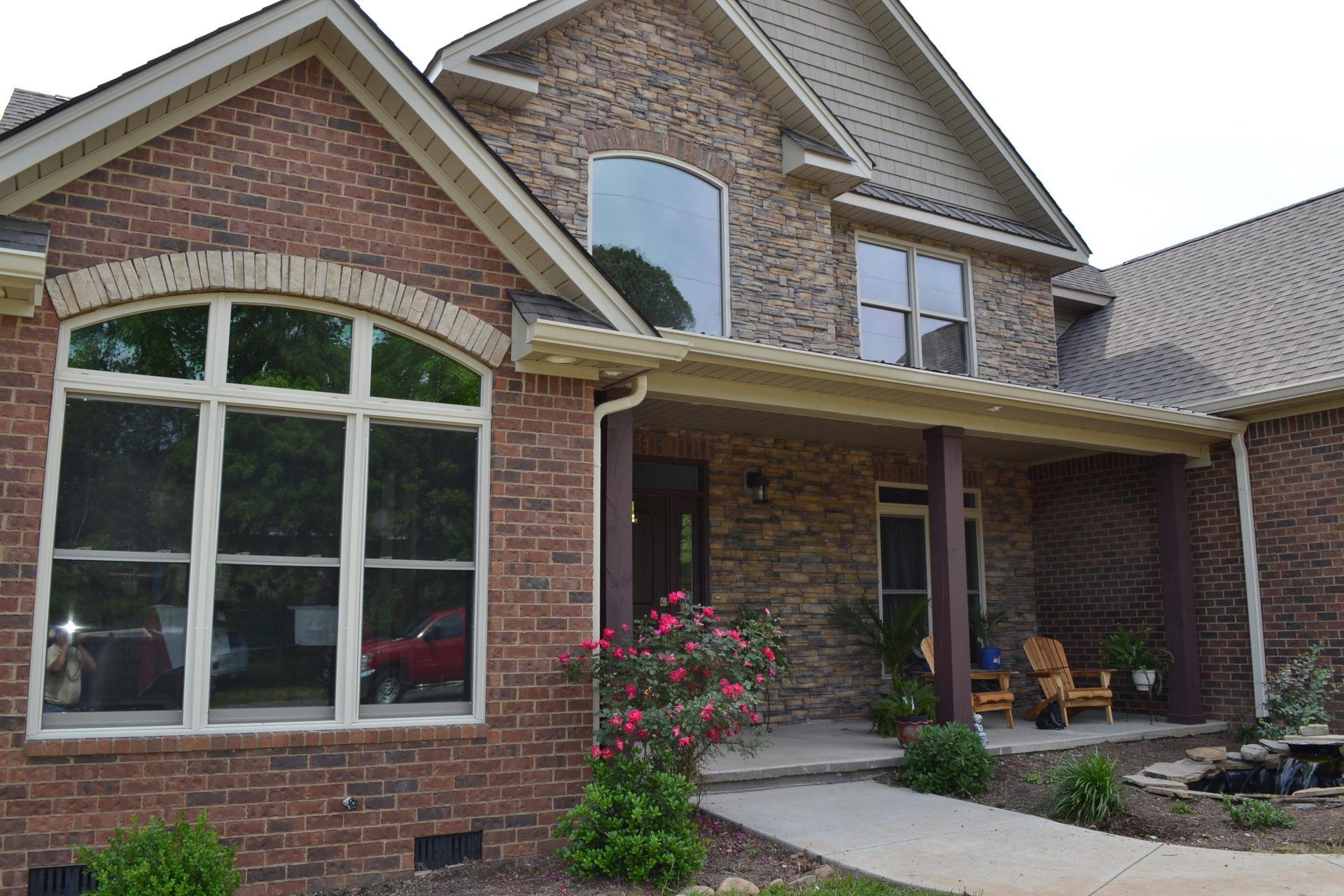 A large brick house with a porch and lots of windows