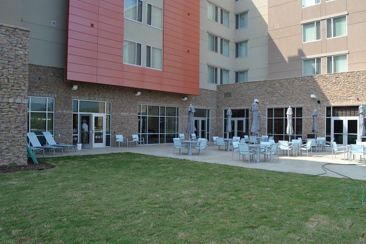 A large building with tables and chairs in front of it