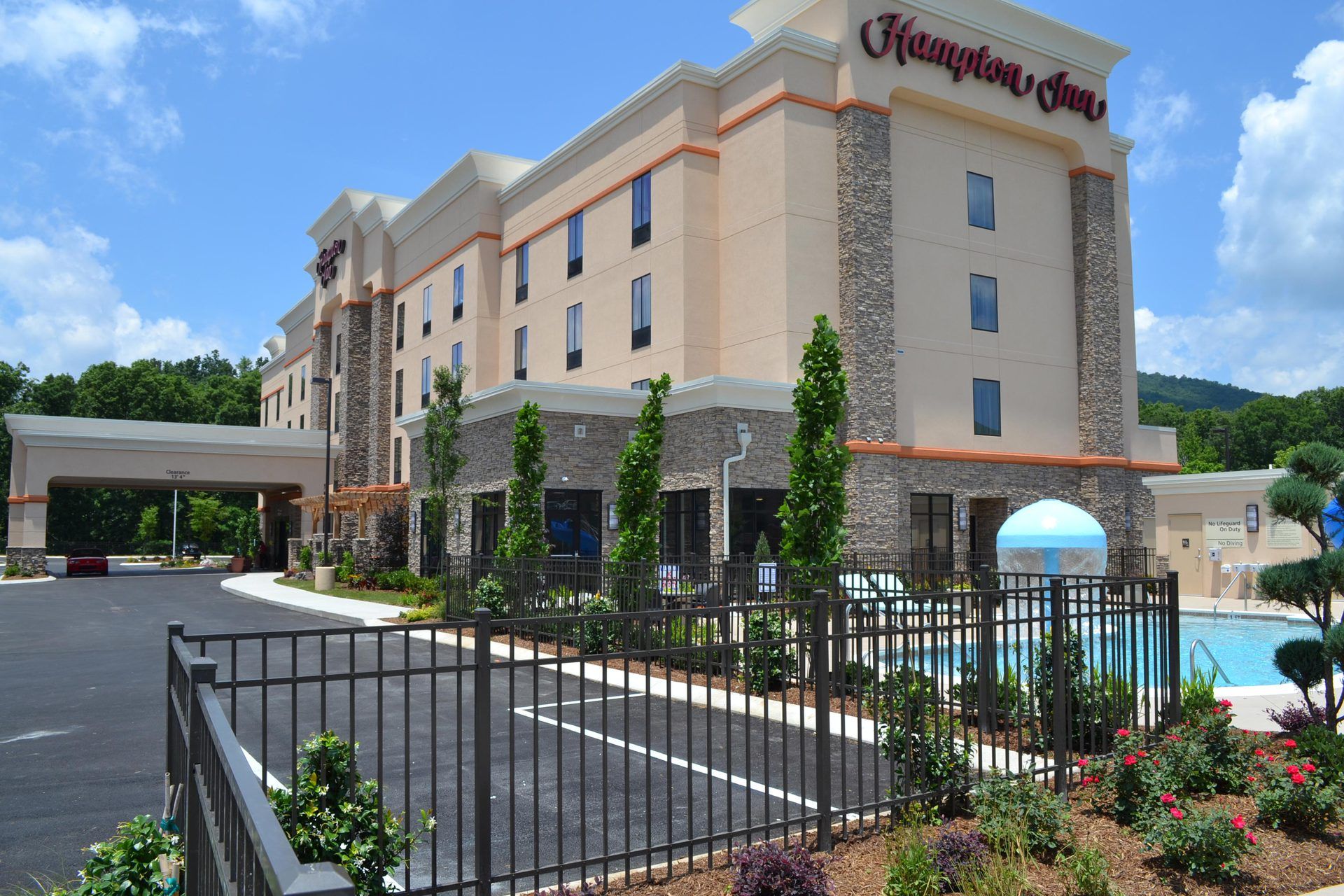 A large hotel with a swimming pool in front of it