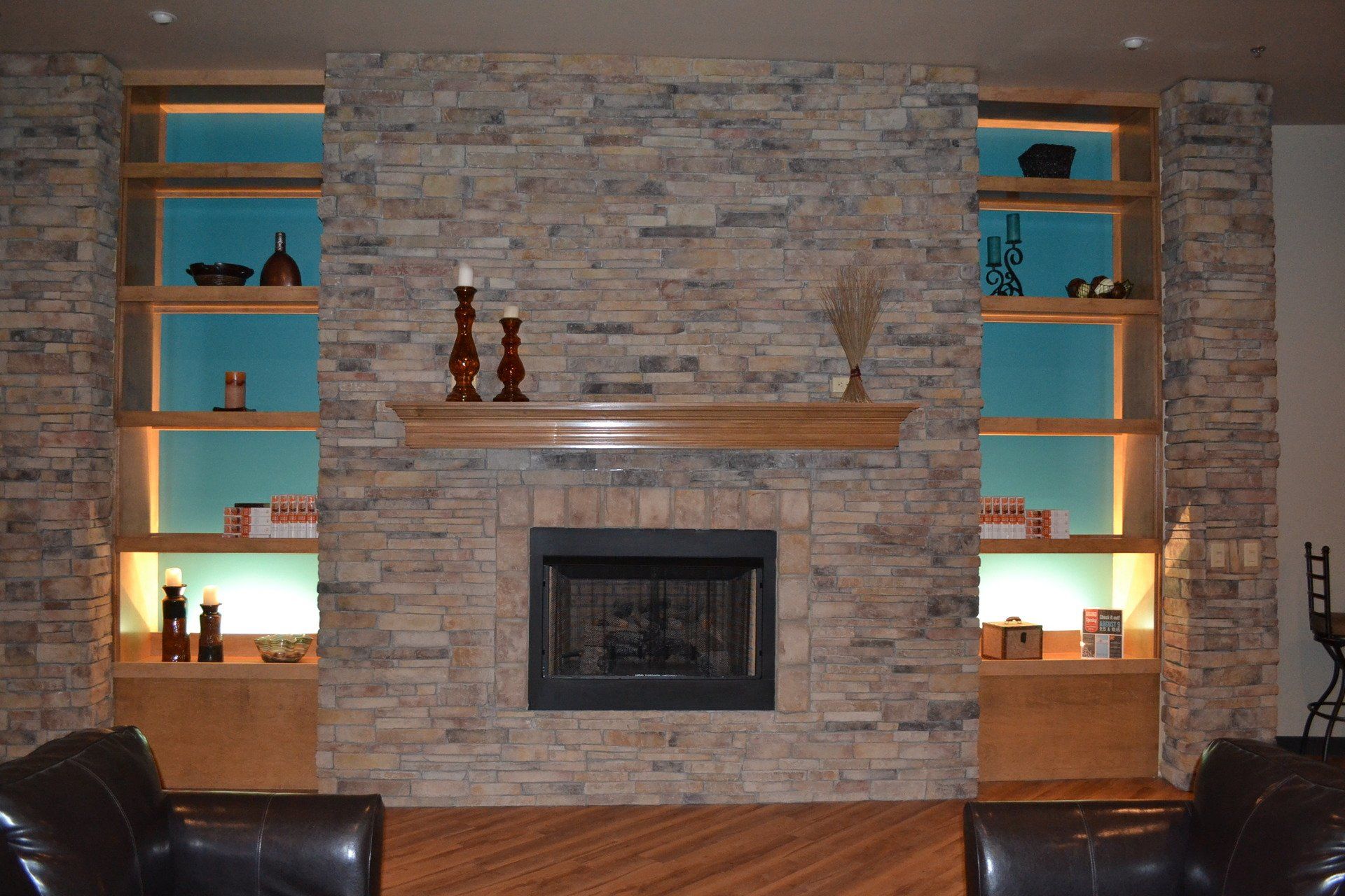 A living room with a brick fireplace and shelves