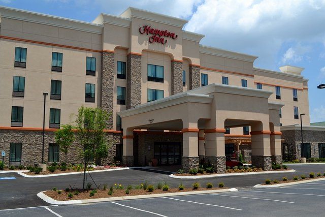 A large hampton inn hotel with a parking lot in front of it