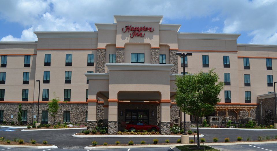A large hotel with a red sign that says hampton inn