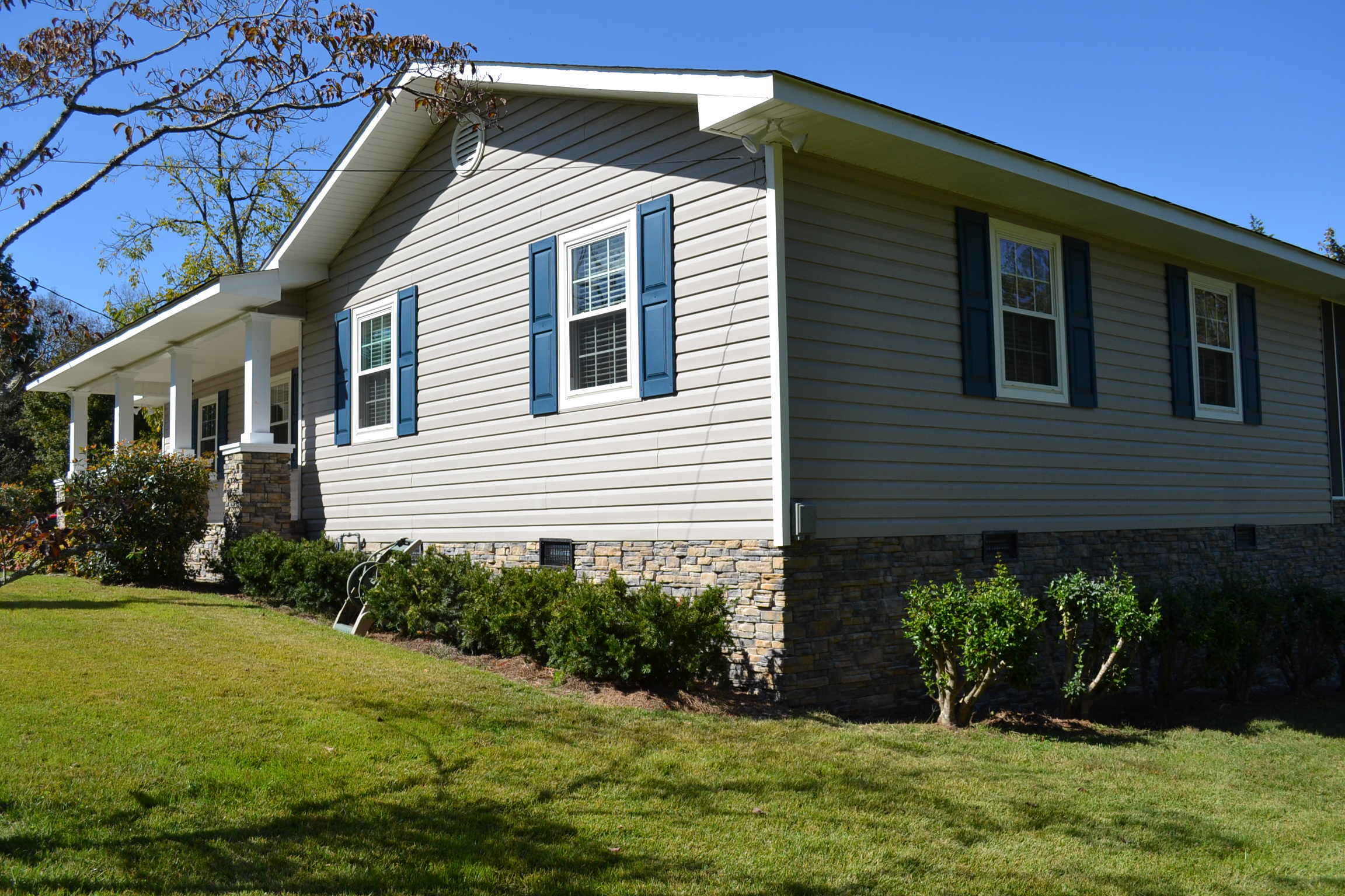 A house with blue shutters and a large porch
