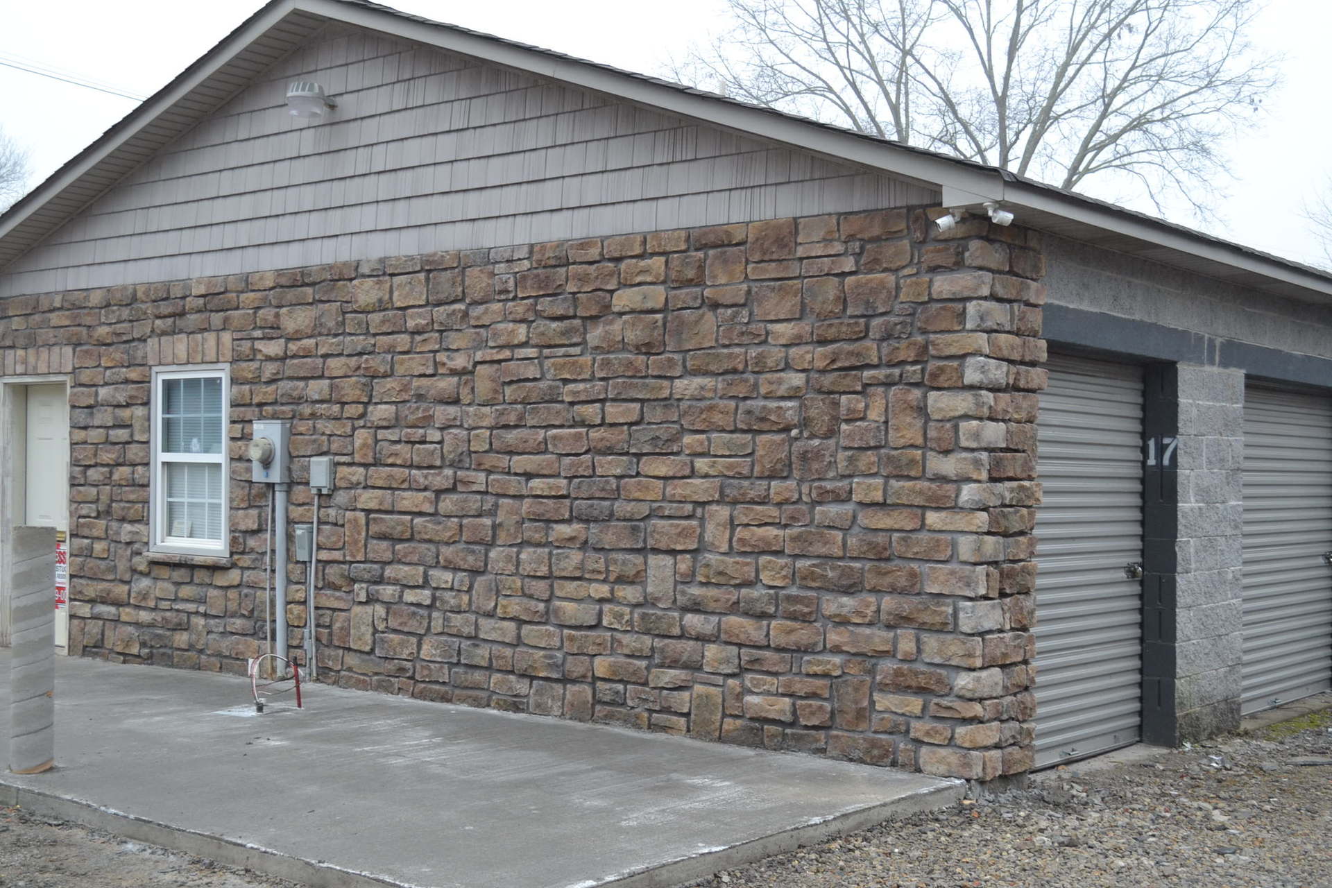 A brick building with a garage and a window