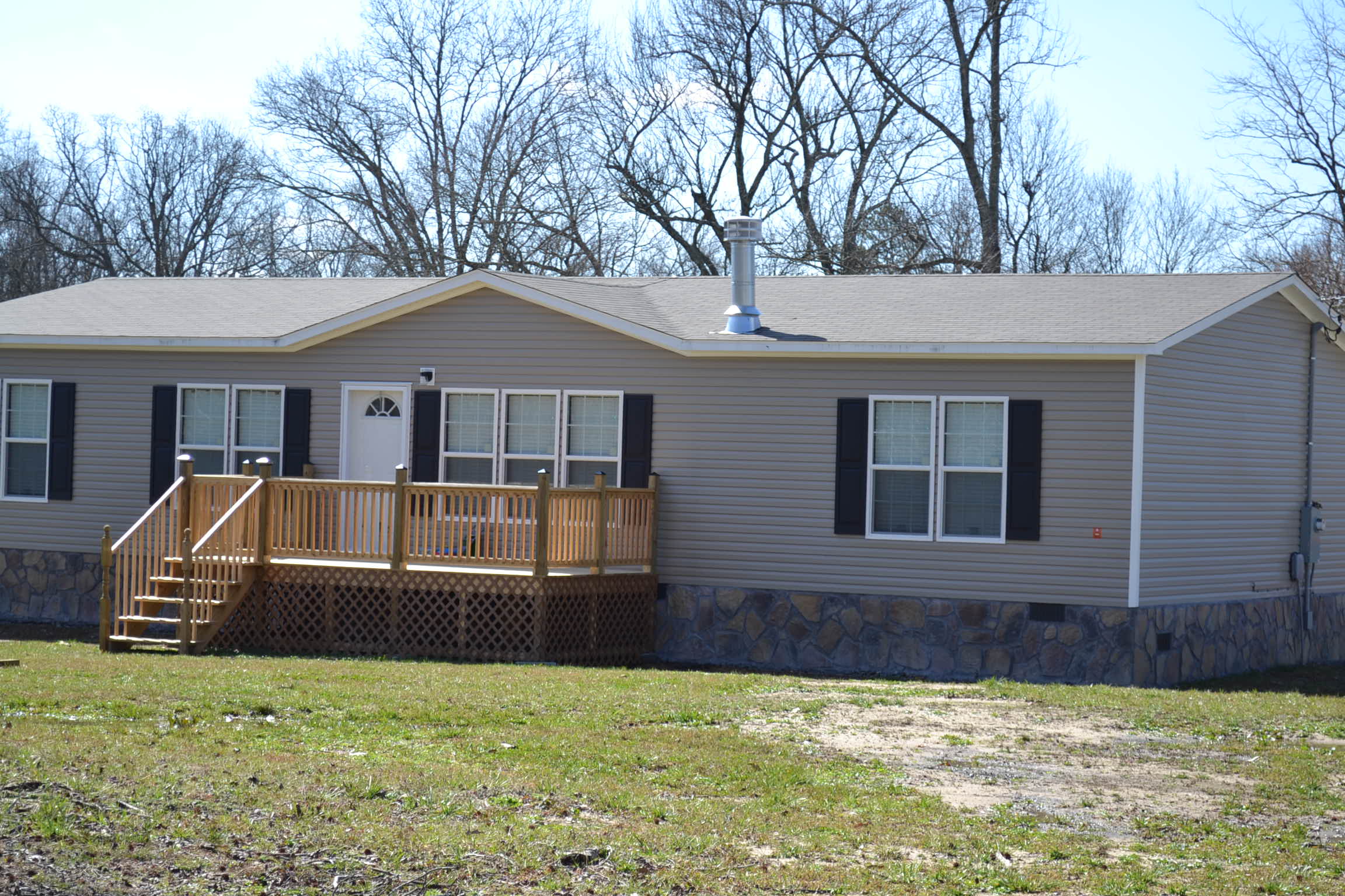 A mobile home with a large deck and stairs