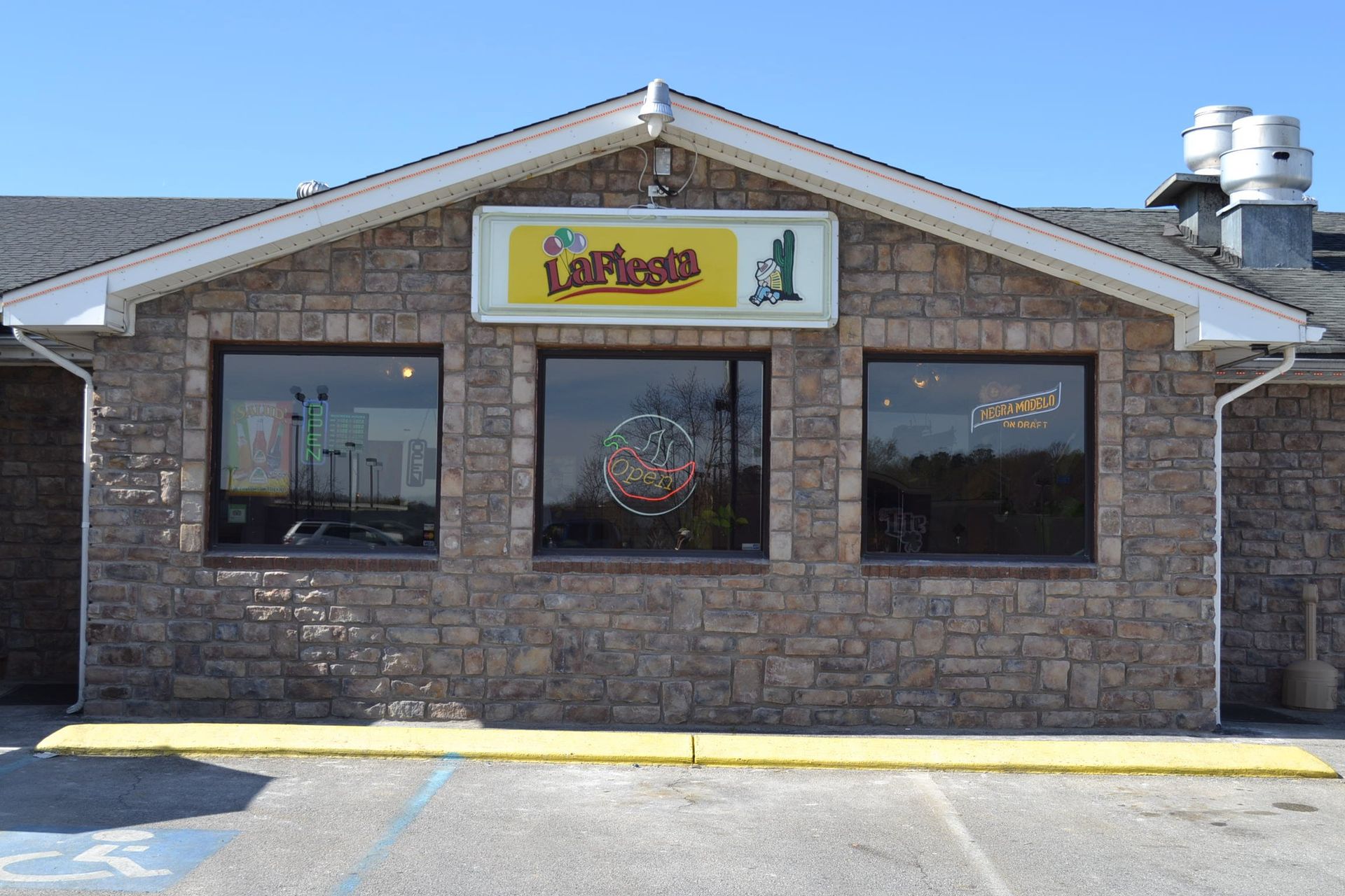 Exterior view of La Fiesta restaurant, a single-story building with a stone facade.