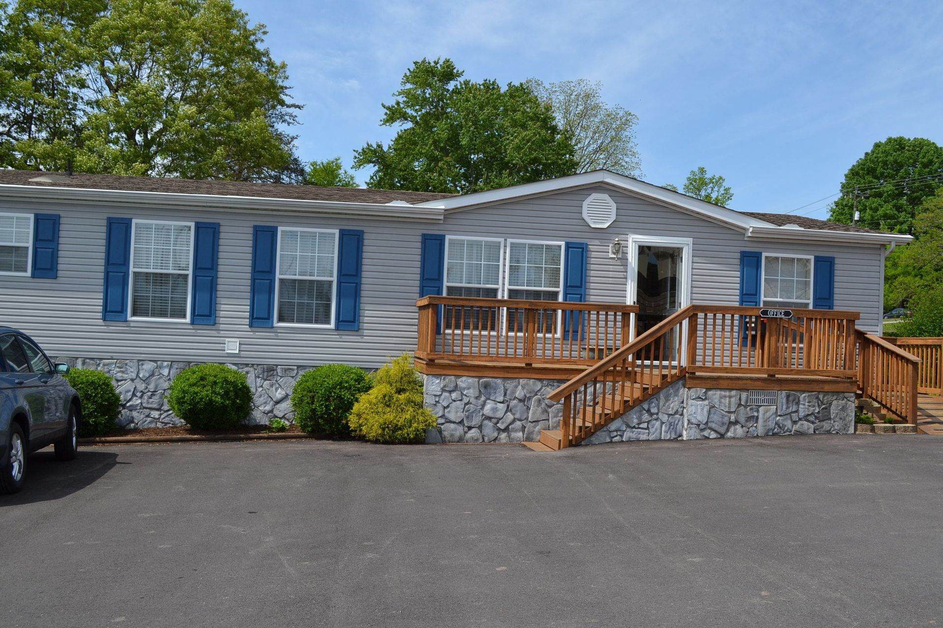 A mobile home with a car parked in front of it.
