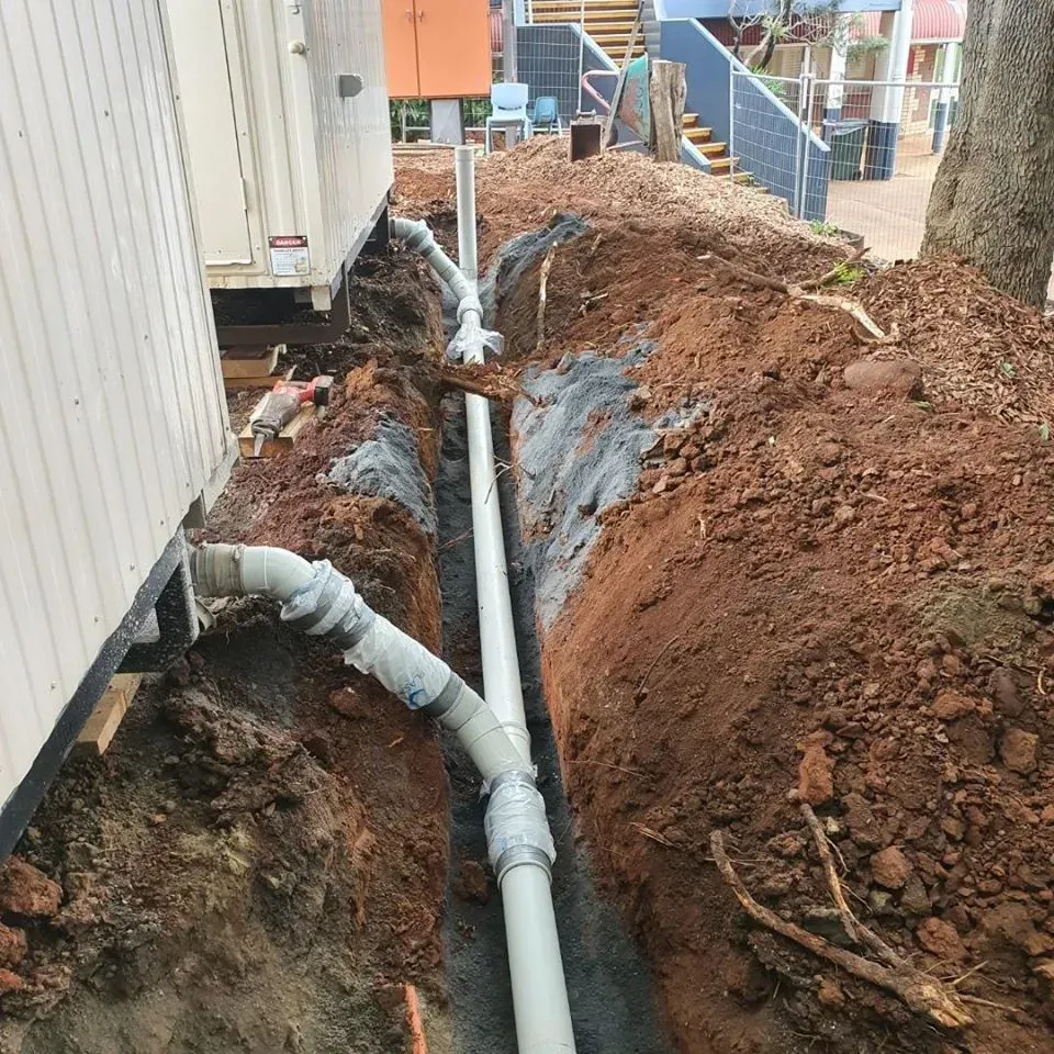 There is a hole in the ground next to a pole.