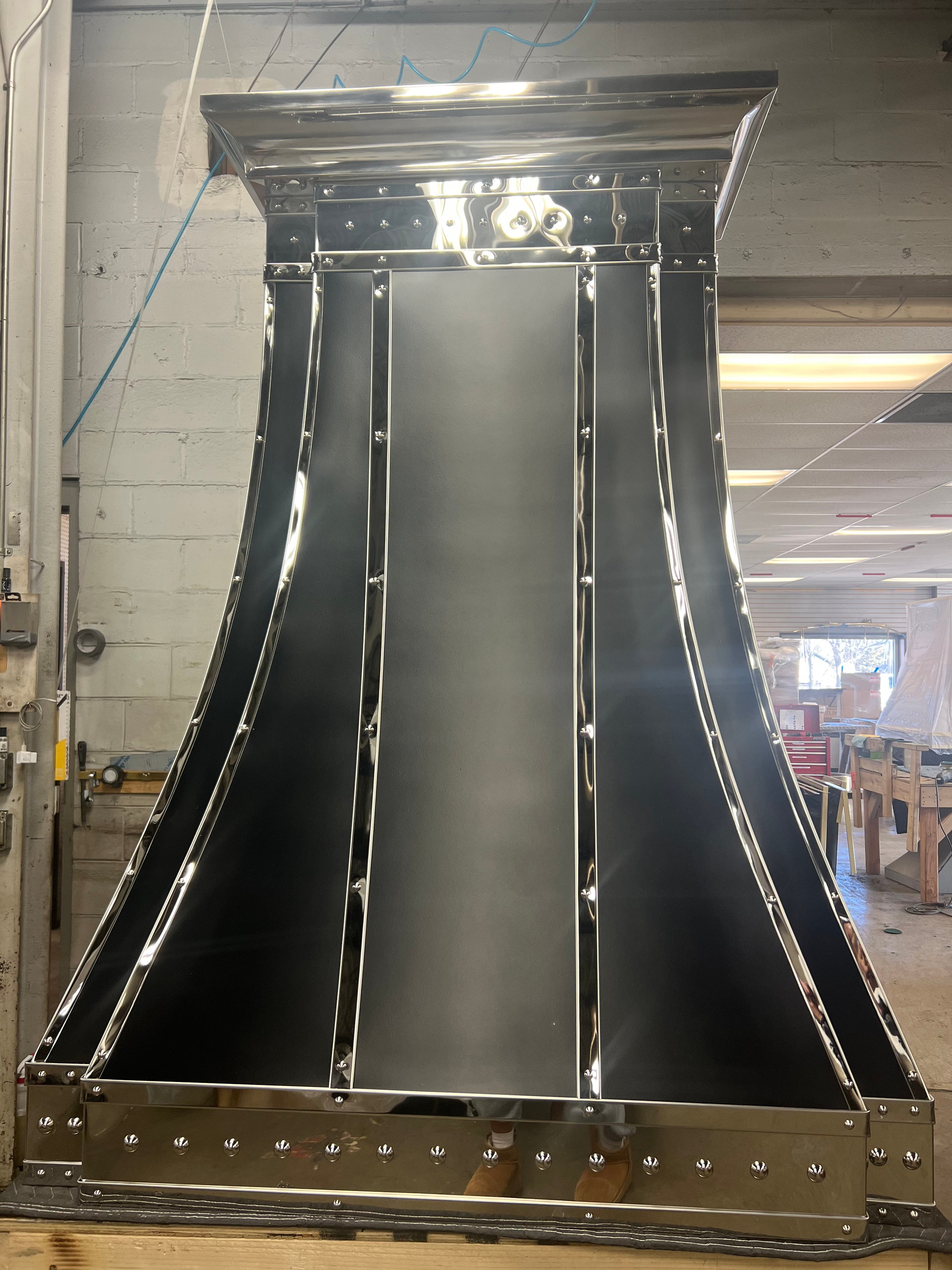 A large metal object is sitting on a wooden table in a room.