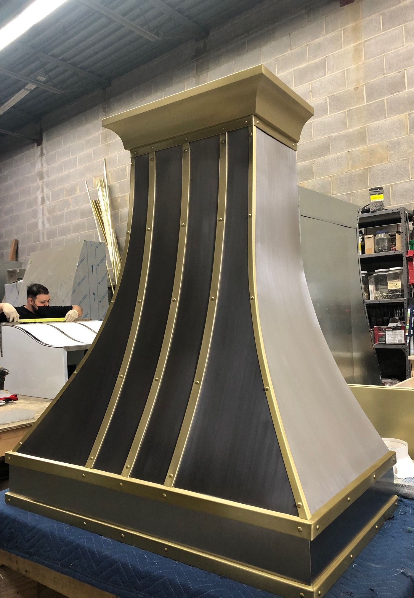 A black and gold hood is sitting on a table in a room.