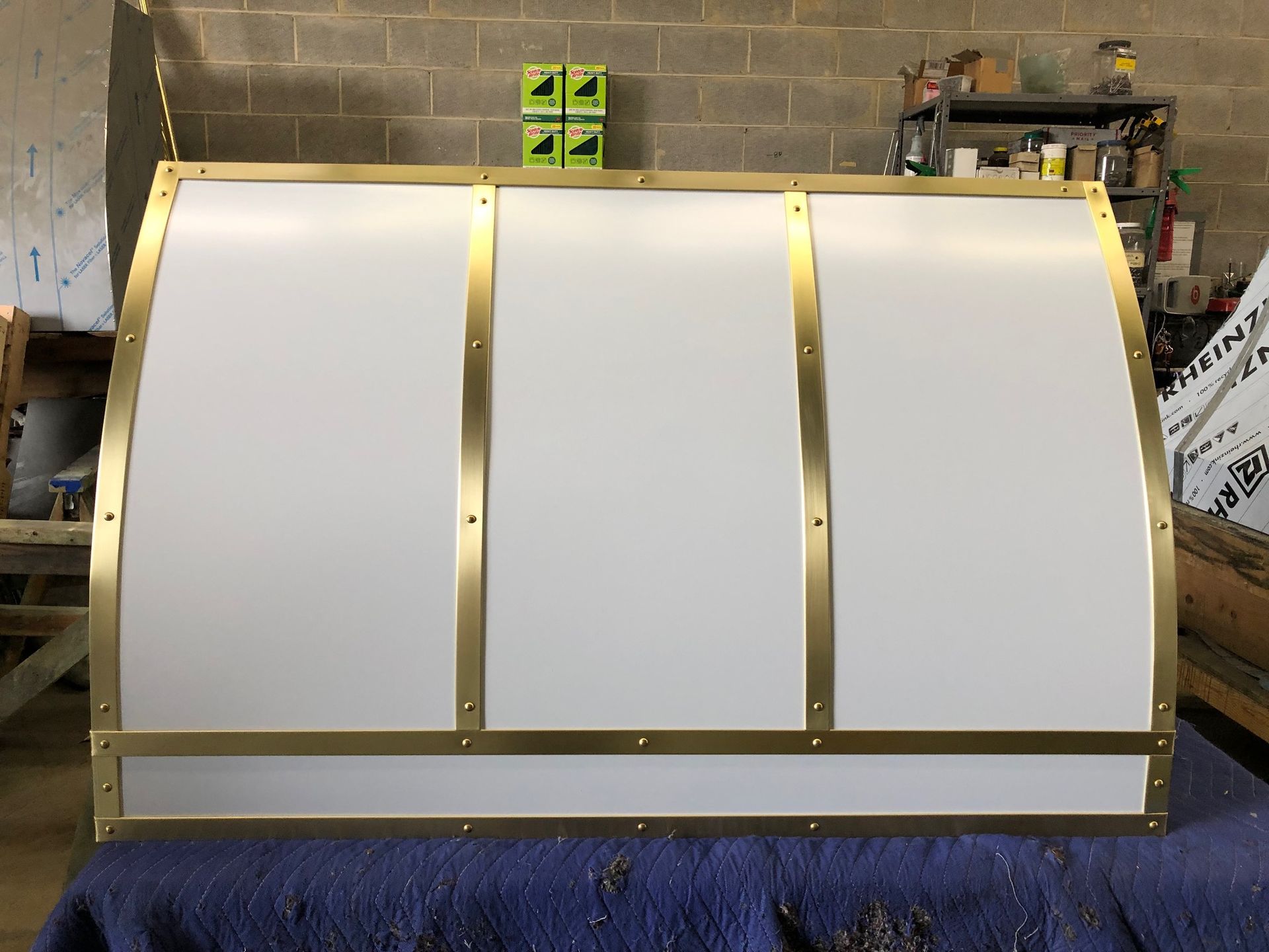 A white box with brass trim is sitting on a blue table.