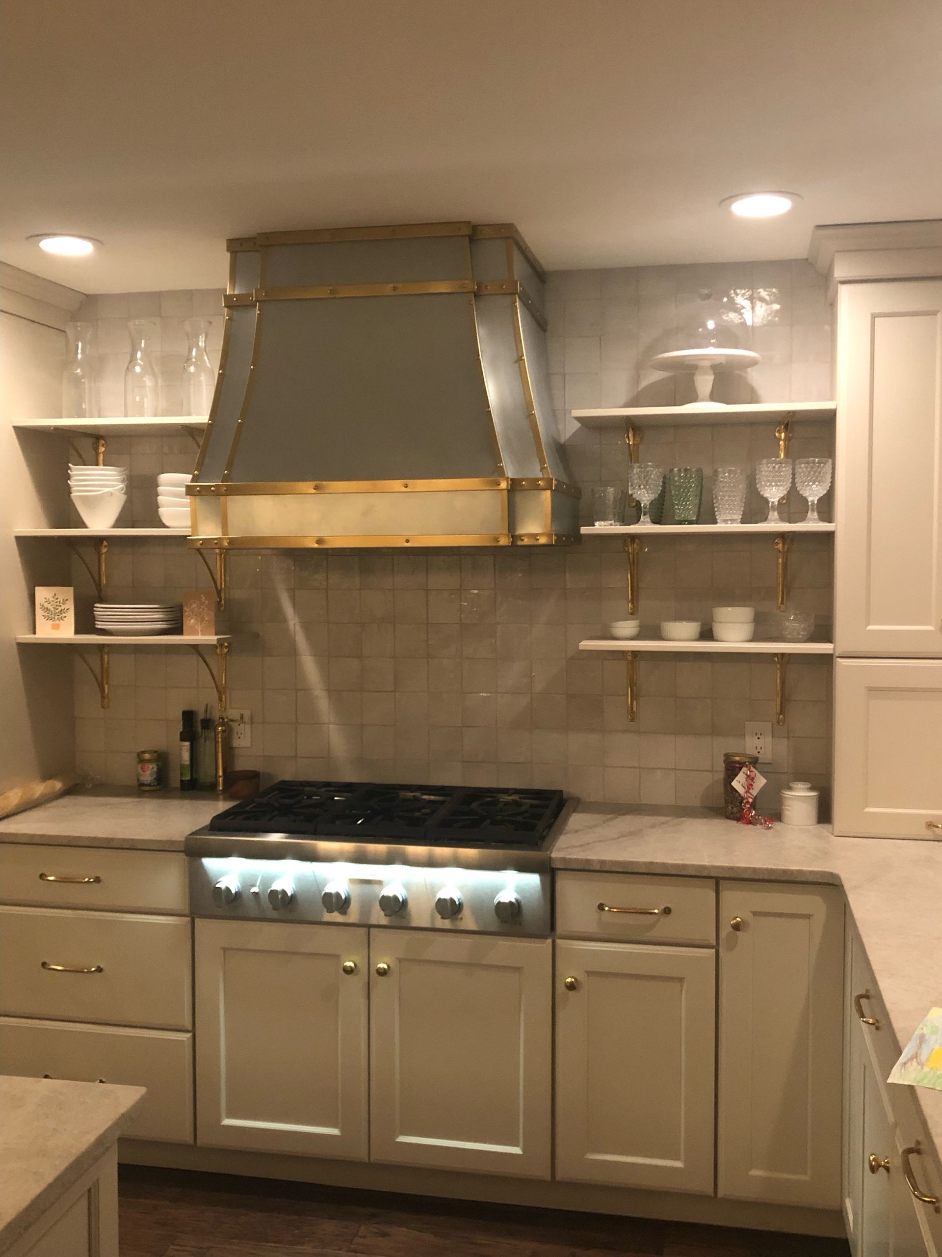 A kitchen with white cabinets and a stove top oven
