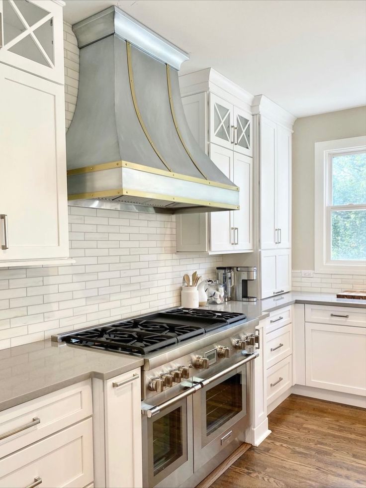 A kitchen with stainless steel appliances and white cabinets.