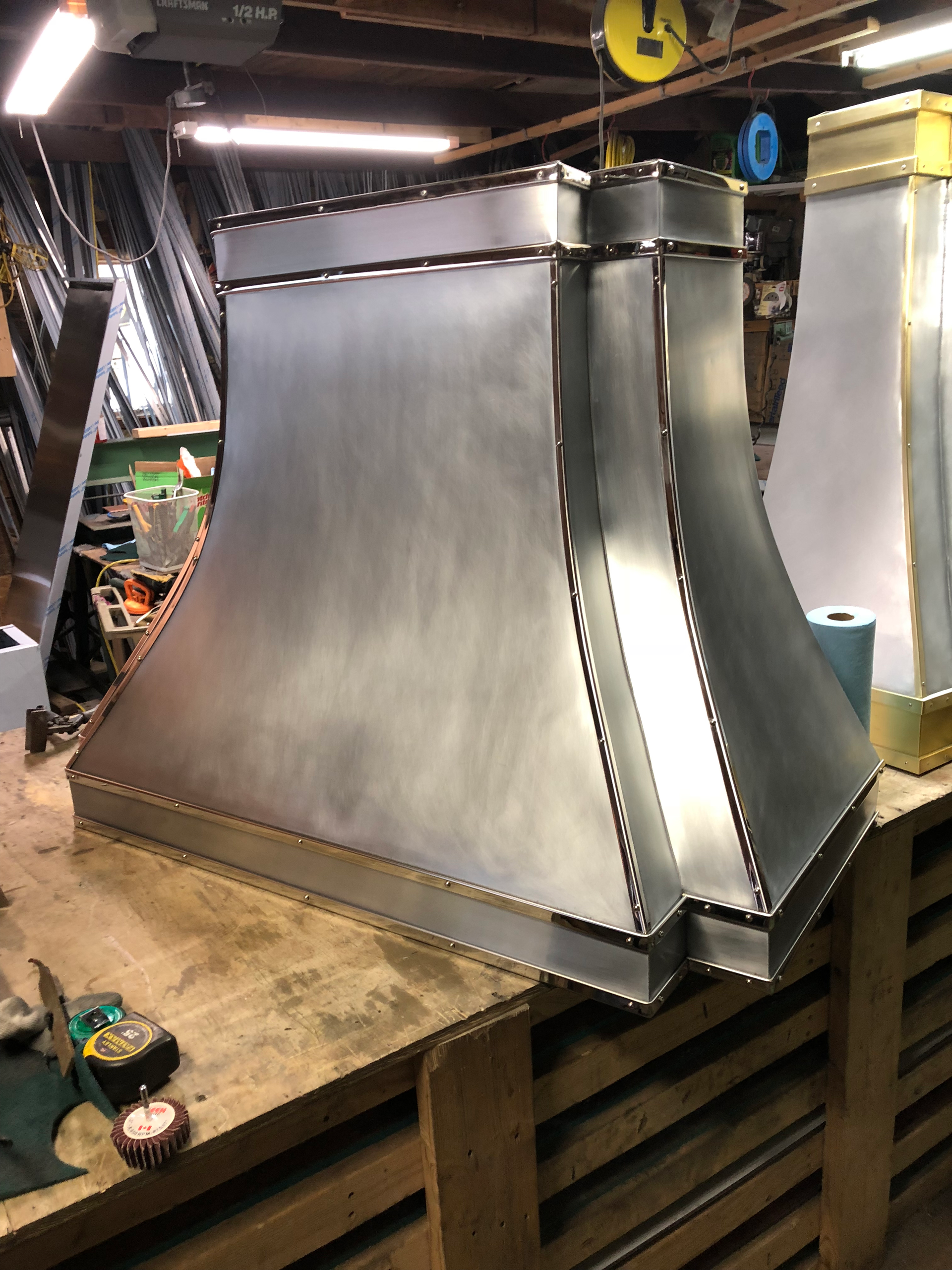 A metal hood is sitting on top of a wooden table.