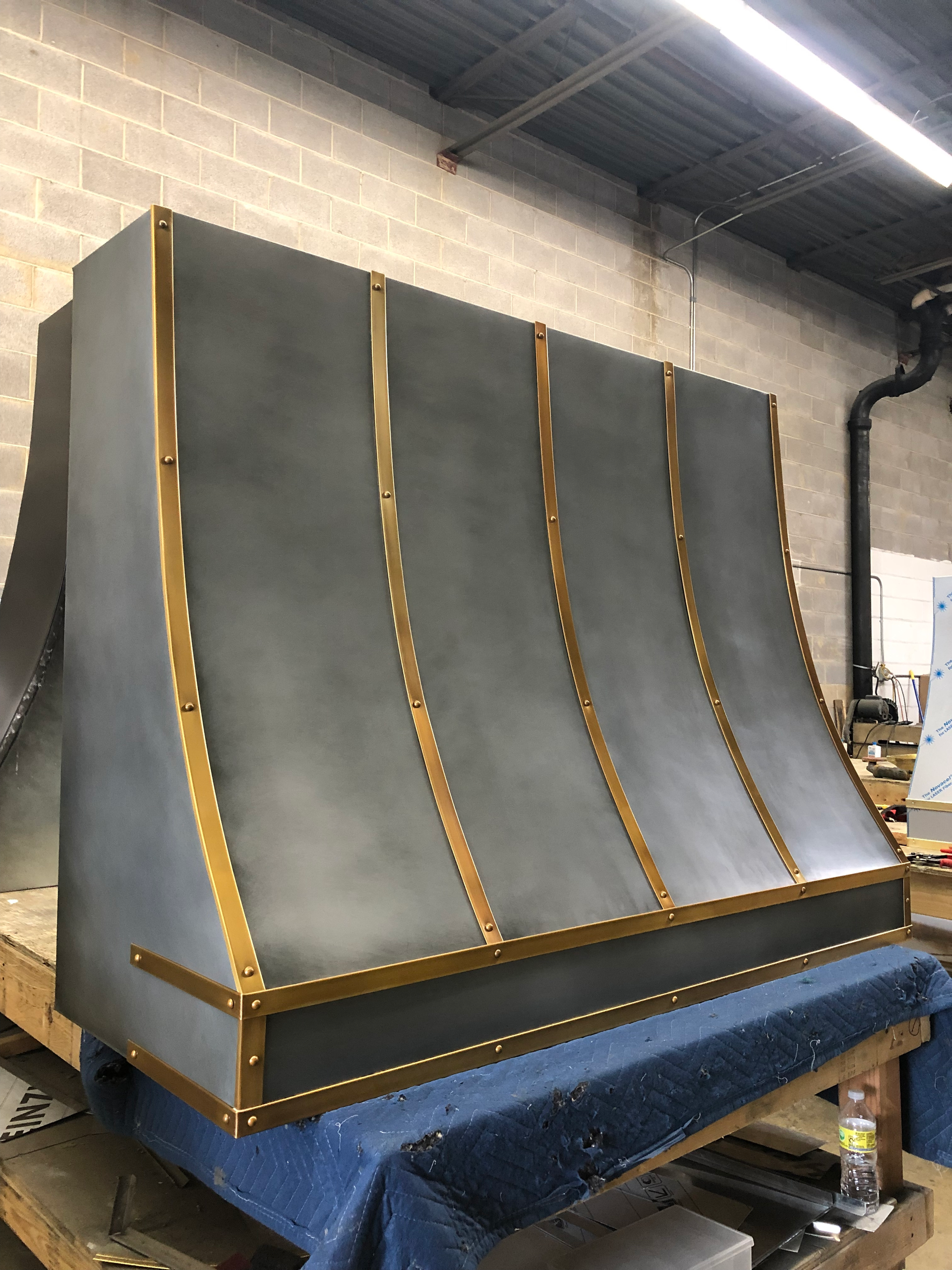 A gray and gold hood is sitting on top of a wooden table.