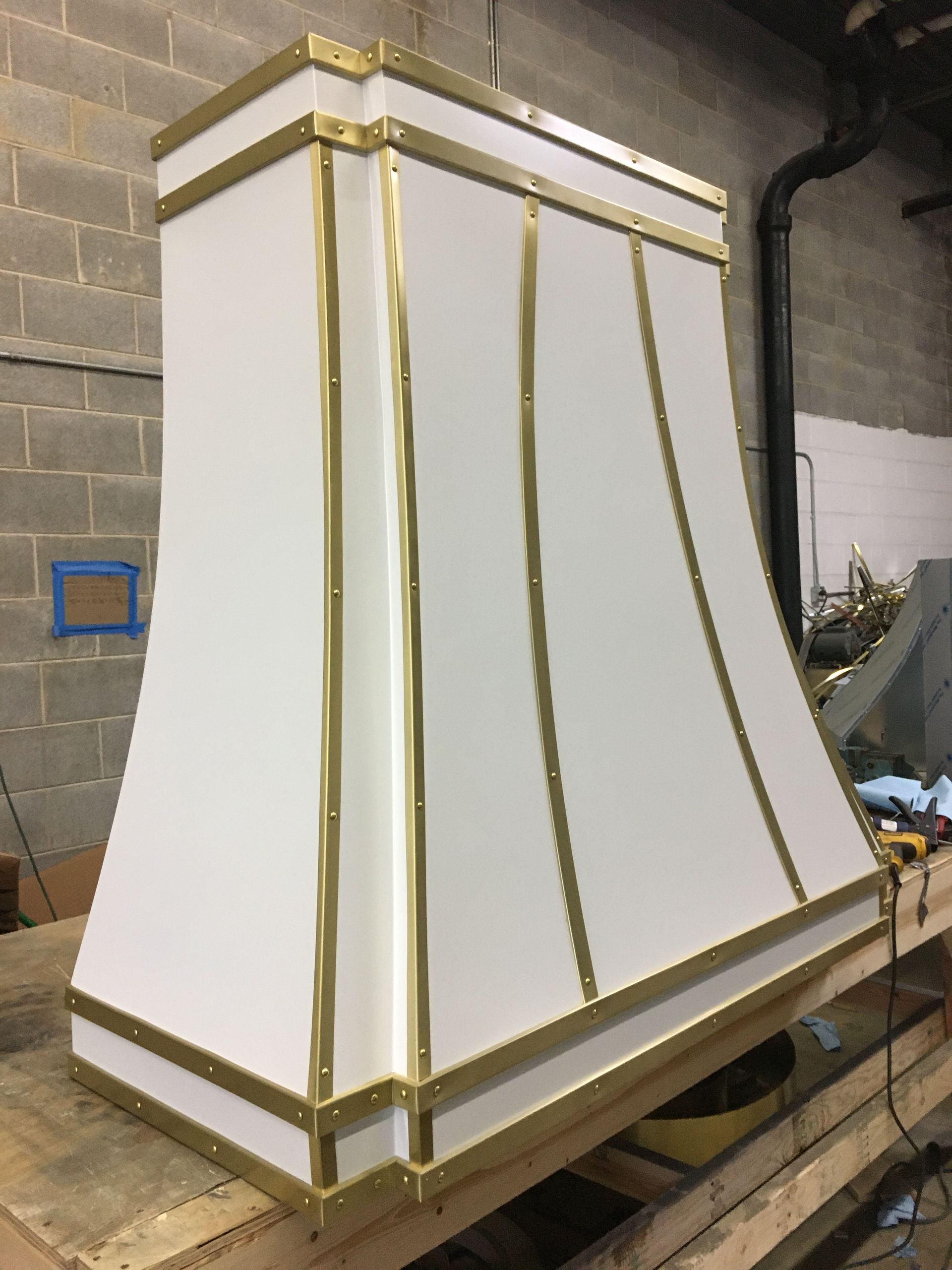 A white and gold hood is sitting on top of a wooden table.