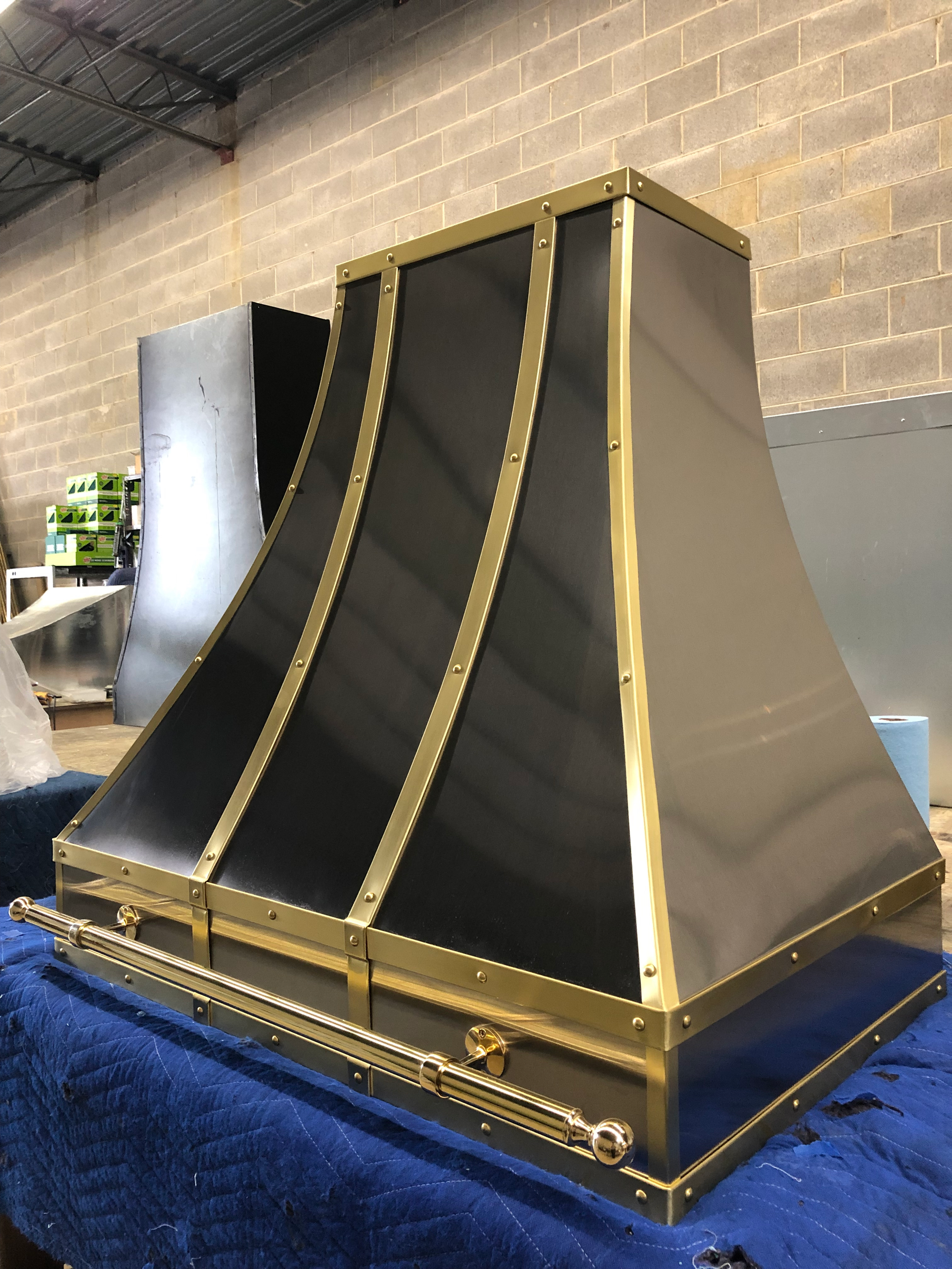 A black and gold hood is sitting on a blue table