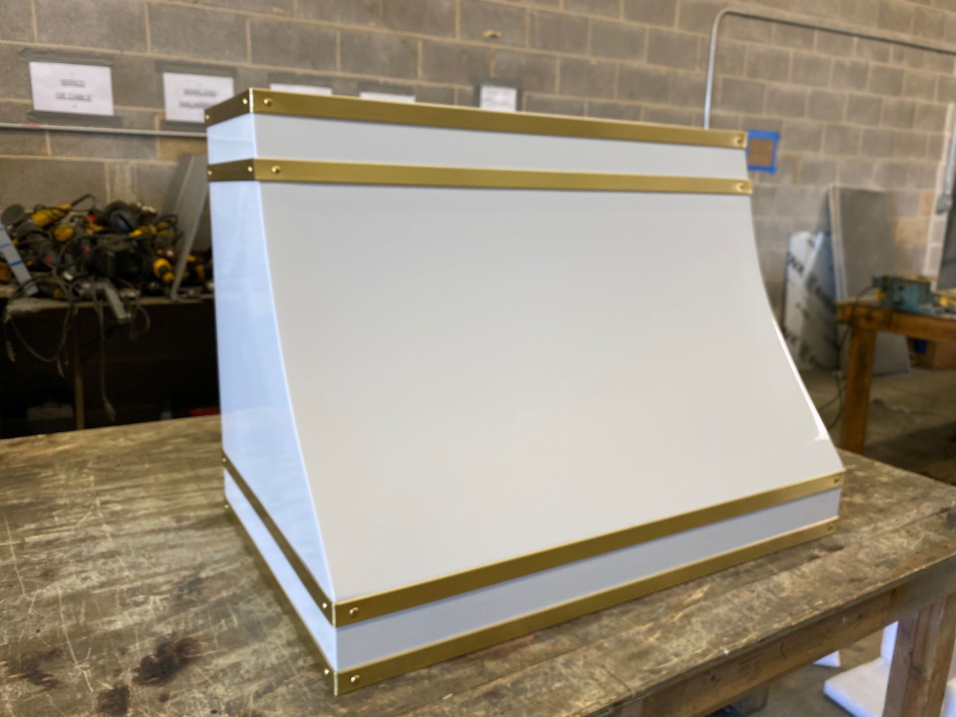 A white box with gold trim is sitting on a wooden table.