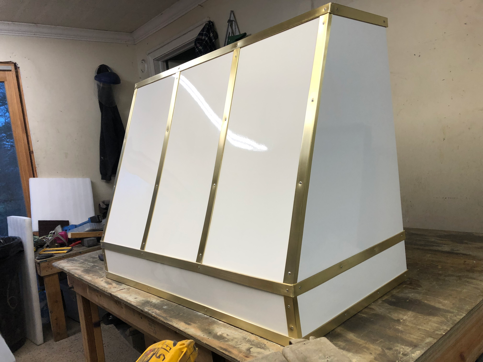A white box with gold trim is sitting on top of a wooden table.