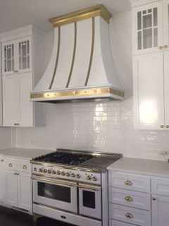 A kitchen with white cabinets and a stove top oven
