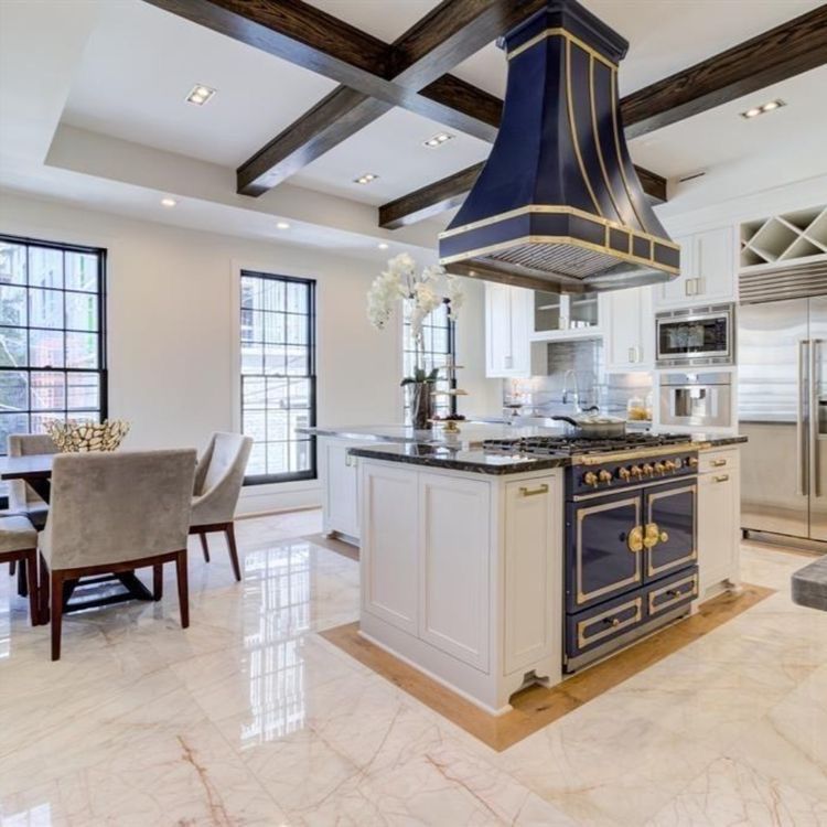 A kitchen with a large island and a stove top oven