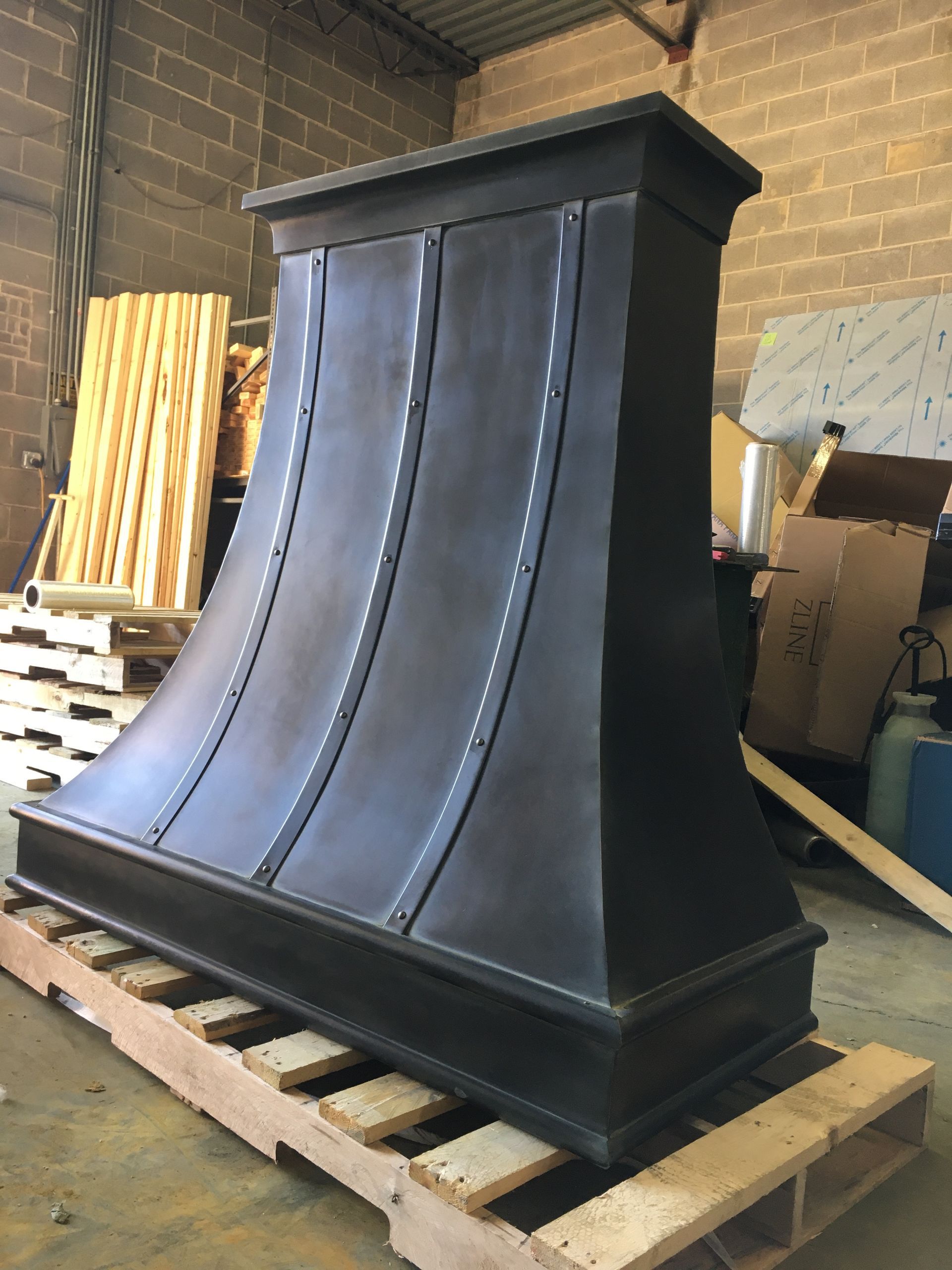 A large black object is sitting on a wooden pallet