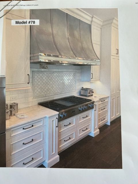 A picture of a kitchen with white cabinets and stainless steel appliances