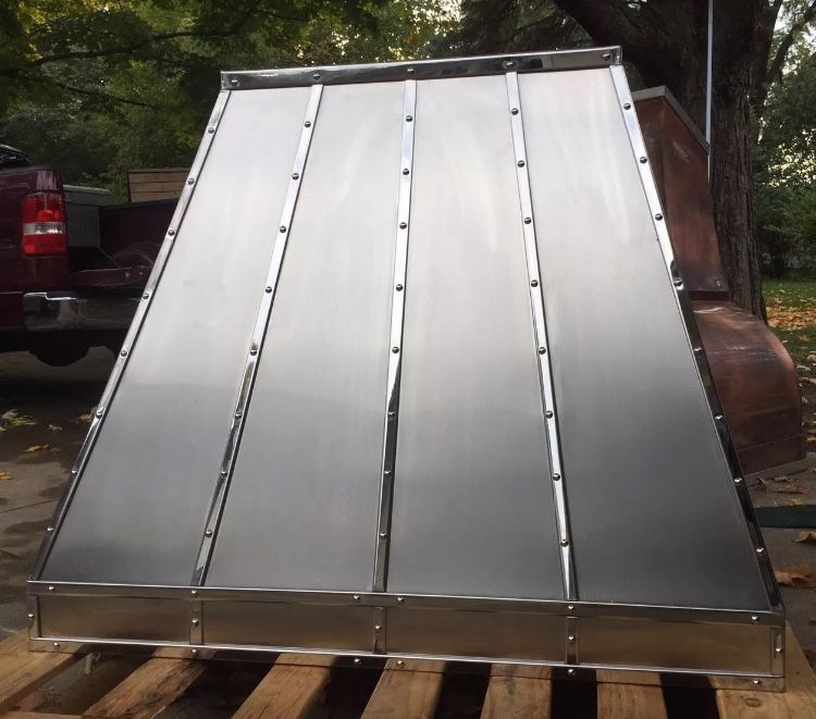 A stainless steel item is sitting on a wooden pallet