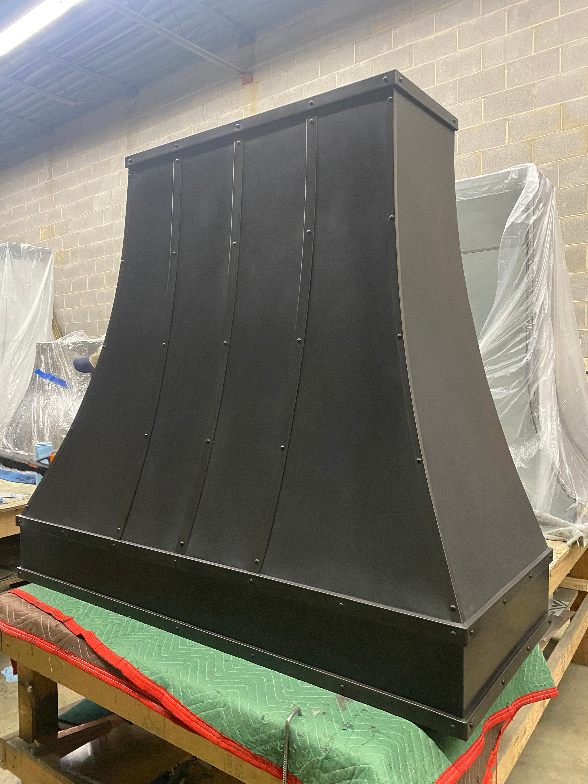 A black hood is sitting on top of a wooden table.