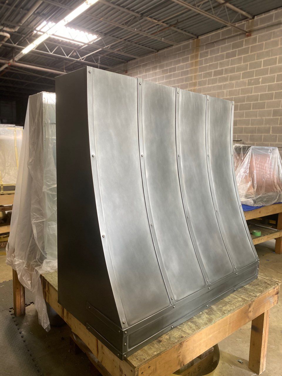 A large metal object is sitting on top of a wooden table in a room.